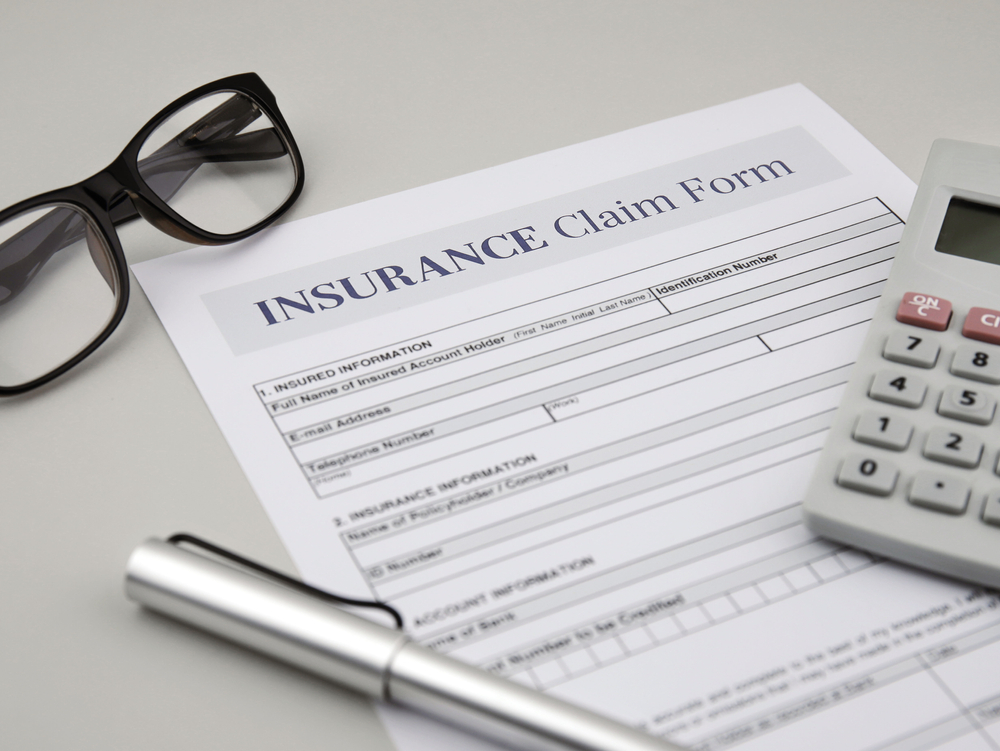 Loss of enjoyment of life claim form on a table with a calculator, pen, and eyeglasses.