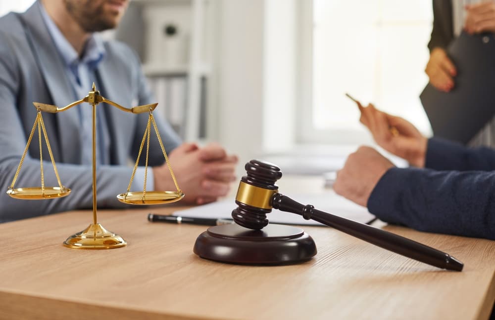 A lawyer meets with a client in the attorney’s office, providing a free case evaluation and discussing legal options for their situation.