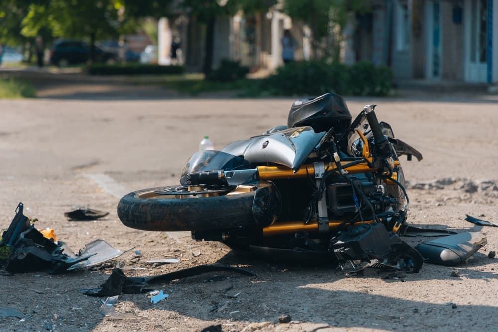 The motorcycle rests on the road after a severe collision. A close-up captures the damaged bike, highlighting the aftermath of the traffic accident.